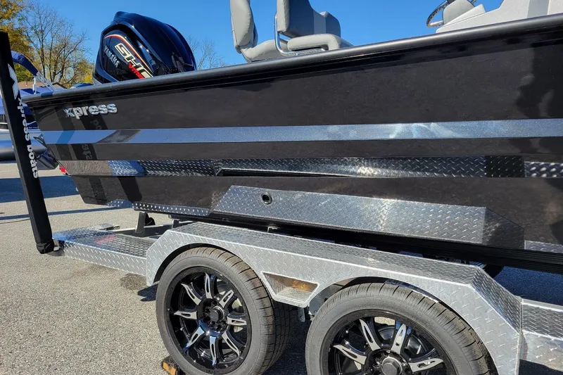 Slide: The Image of 2026 Xpress X23 Bay Lounge boat on trailer, featuring sleek black design and shiny wheels. - 3