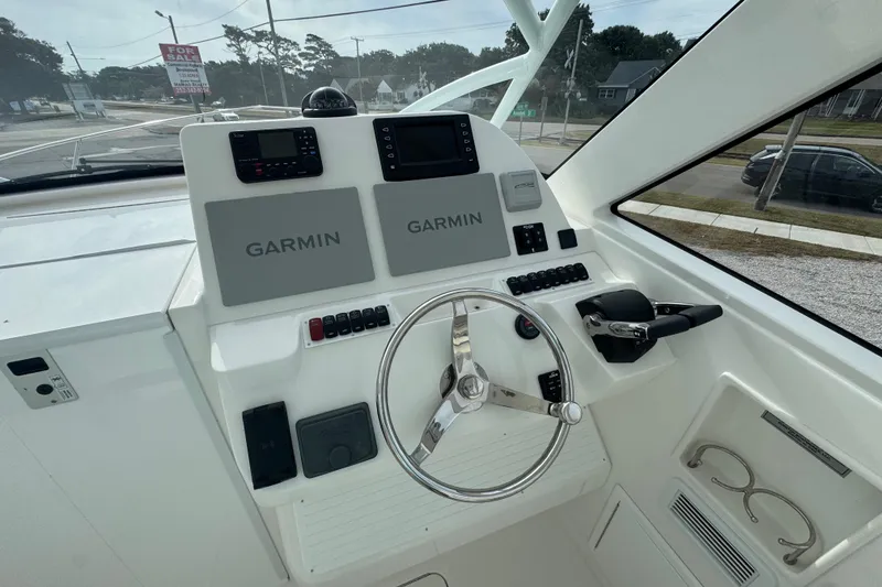 Slide: The Image of 2024 Albemarle 30 Express helm with Garmin navigation, steering wheel, and control panel. - 8