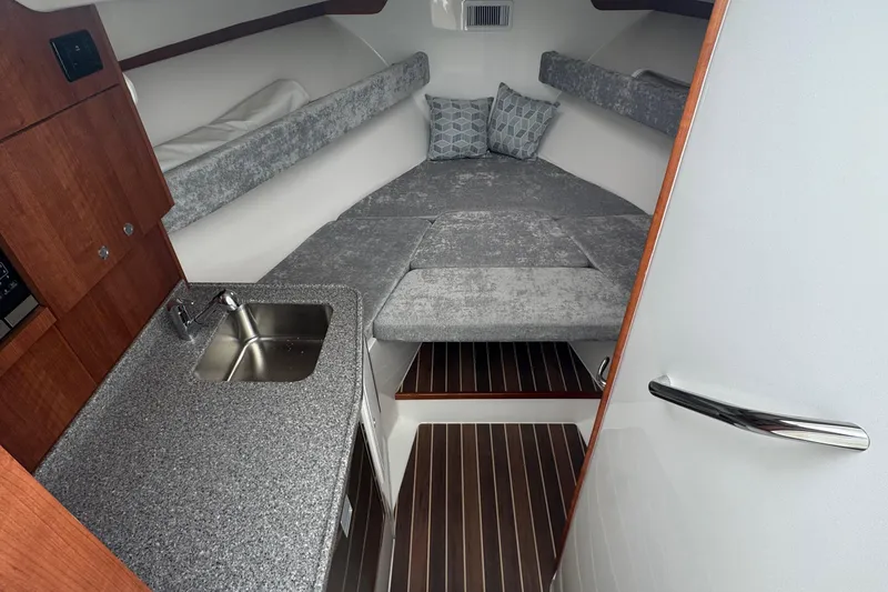 Slide: The Image of 2024 Albemarle 30 Express cabin interior with bed, sink, and wooden cabinetry. - 9
