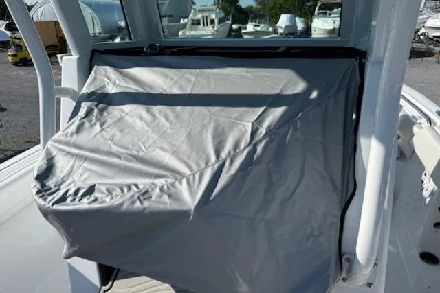 Slide: The Image of 2025 Wellcraft 223 Fisherman boat console covered with a protective gray tarp. - 15