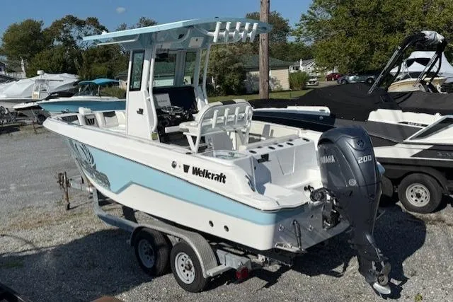 Slide: The Image of 2025 Wellcraft 223 Fisherman boat on trailer, featuring Yamaha 200 engine, parked outdoors. - 2