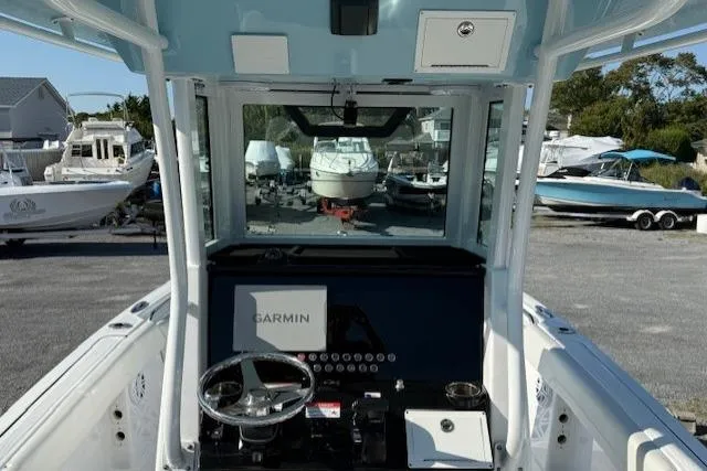 Slide: The Image of 2025 Wellcraft 223 Fisherman boat interior with Garmin navigation system, steering wheel, and control panel. - 5