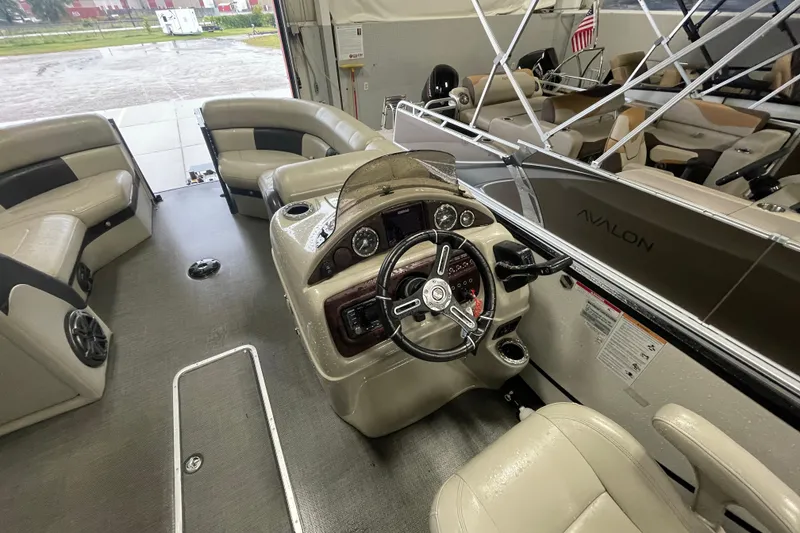 Slide: The Image of Interior of 2020 South Bay 523E 2.75 pontoon boat with plush seating and modern dashboard. - 11