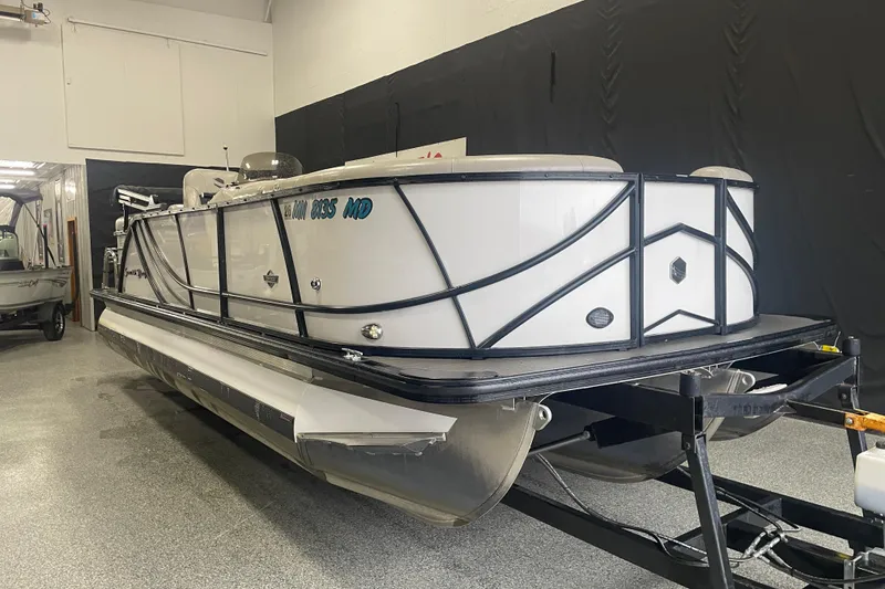 Slide: The Image of 2020 South Bay 523E 2.75 pontoon boat with Suzuki outboard motor in showroom. - 2