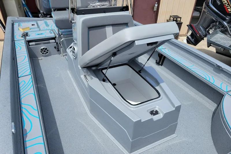 Slide: The Image of 2026 Xpress X23 Bay Lounge boat interior with open storage compartment and seating. - 5
