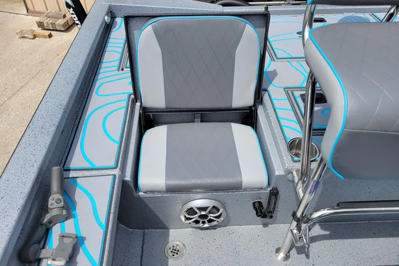 Slide: The Image of 2026 Xpress X23 Bay Lounge boat interior with gray and blue seating and speaker. - 6