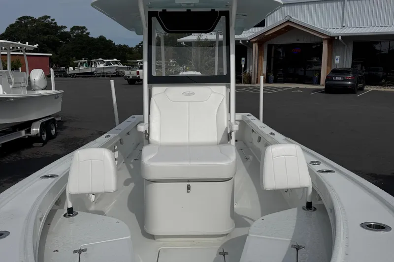 Slide: The Image of 2025 Pair Customs 24 Center Console MV boat with white seating, docked outdoors. - 2