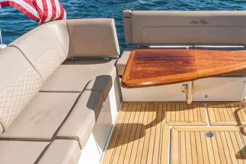 Slide: The Image of 2017 Sea Ray 460 Sundancer yacht with elegant seating and wooden table on deck. - 3