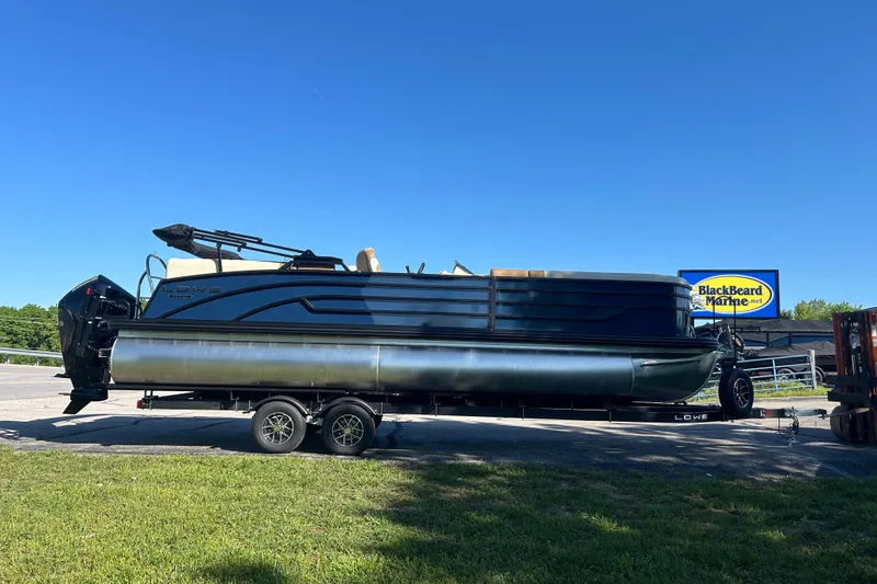 The Image of 2025 Lowe SS 250 WT pontoon boat on trailer at BlackBeard Marine dealership. - 0