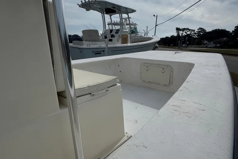 Slide: The Image of 2007 Jones Brothers 20 Bateau boat with seating and storage, parked near another vessel. - 4