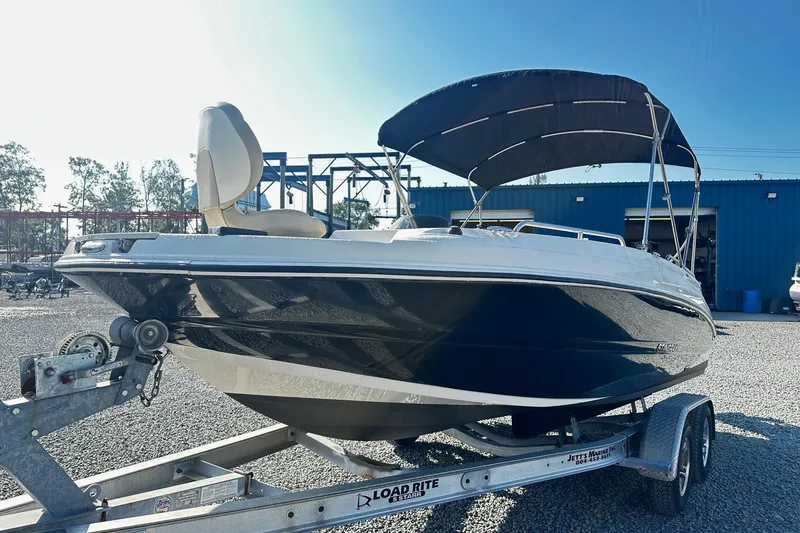 Slide: The Image of 2016 Stingray 192SC boat on trailer with canopy, parked outdoors. - 0