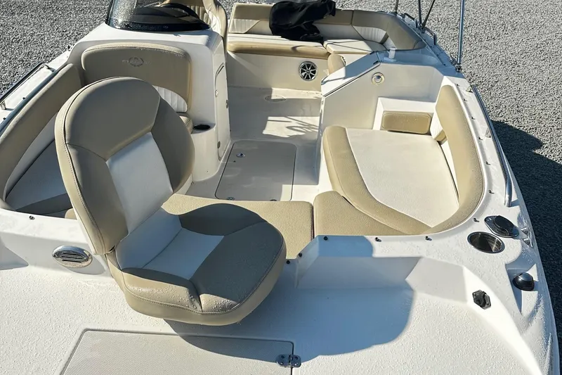 Slide: The Image of 2016 Stingray 192SC boat interior with beige and white seating, cup holders, and spacious layout. - 10