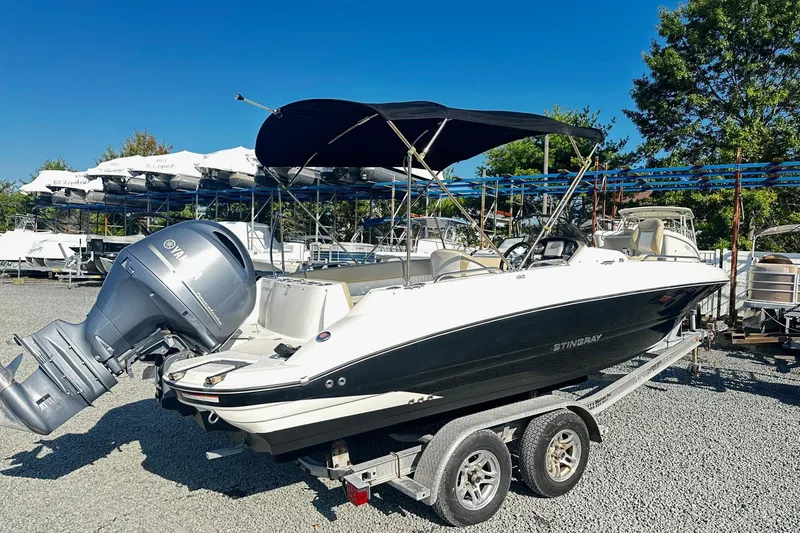 Slide: The Image of 2016 Stingray 192SC boat on trailer with Yamaha outboard motor, parked outdoors. - 2