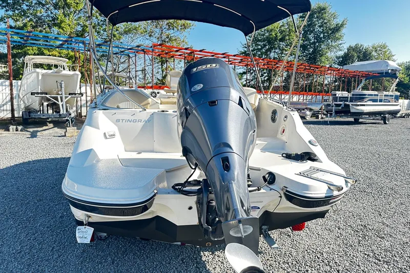 Slide: The Image of 2016 Stingray 192SC boat with outboard motor, parked on gravel lot. - 4