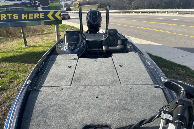 Slide: The Image of 2025 Skeeter ZXR21 fishing boat with spacious deck and modern seating, parked roadside. - 4