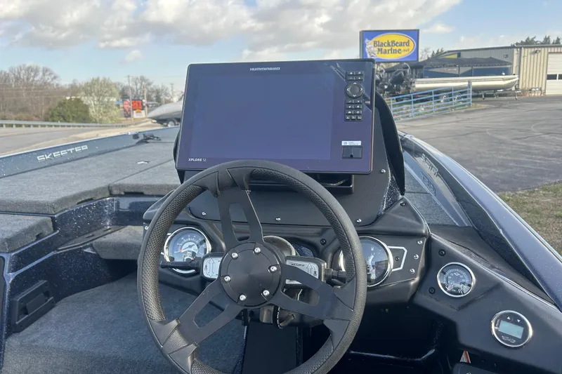 Slide: The Image of 2025 Skeeter ZXR21 boat dashboard with steering wheel and navigation display at BlackBeard Marine. - 5