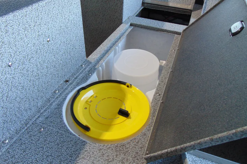 Slide: The Image of 2026 Crestliner 1650 Kodiak boat storage compartment with yellow lid and interior bucket. - 11