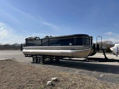 Slide: The Image of 2025 Lowe LS 230 WT pontoon boat on trailer under clear blue sky. - 1
