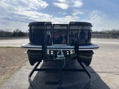Slide: The Image of 2025 Lowe LS 230 WT pontoon boat on trailer under a partly cloudy sky. - 2