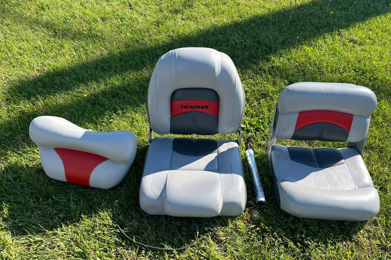 Slide: The Image of 2008 Tracker Pro Team 175 TXW boat seats on grass, featuring gray and red design. - 20