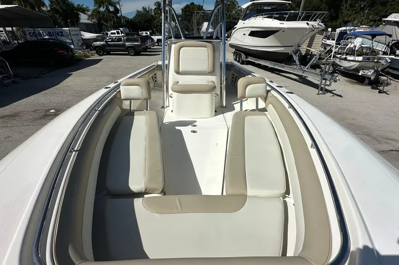 Slide: The Image of 2012 Blackwood 270 boat interior with beige seating, docked near other boats. - 6