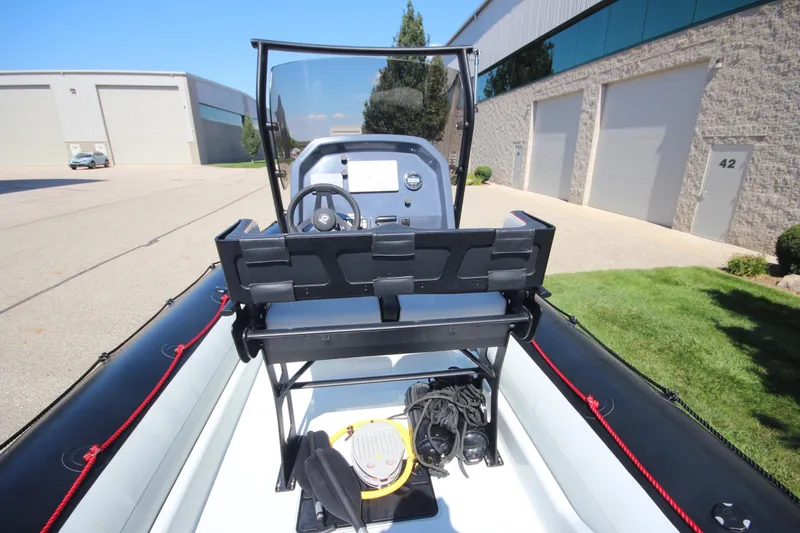 Slide: The Image of 2018 Zodiac Open 7 NEO boat with trailer, parked near industrial buildings. - 12