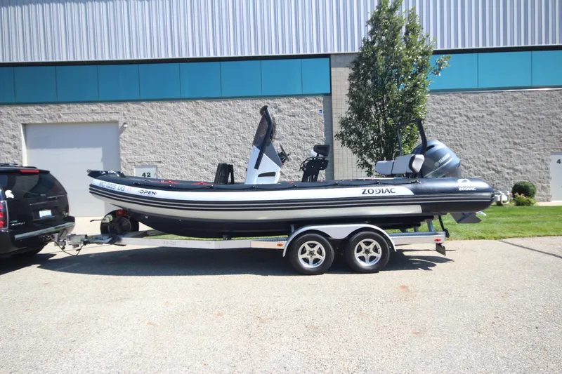 Slide: The Image of 2018 Zodiac Open 7 NEO boat on trailer, parked outdoors near a building. - 26
