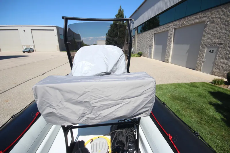 Slide: The Image of 2018 Zodiac Open 7 NEO boat on trailer, parked near industrial buildings. - 3