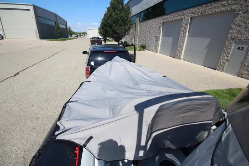 Slide: The Image of 2018 Zodiac Open 7 NEO boat on trailer, covered, parked near industrial buildings. - 4