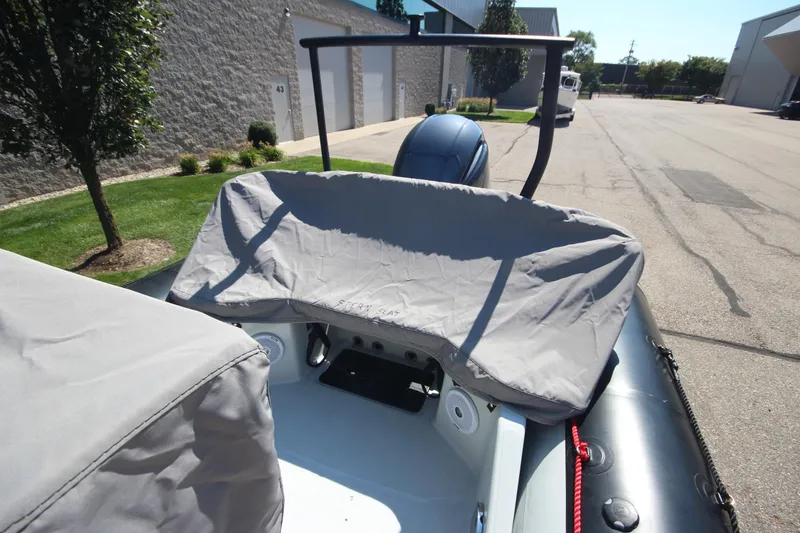 Slide: The Image of 2018 Zodiac Open 7 NEO boat with trailer, covered seats, parked outdoors. - 5