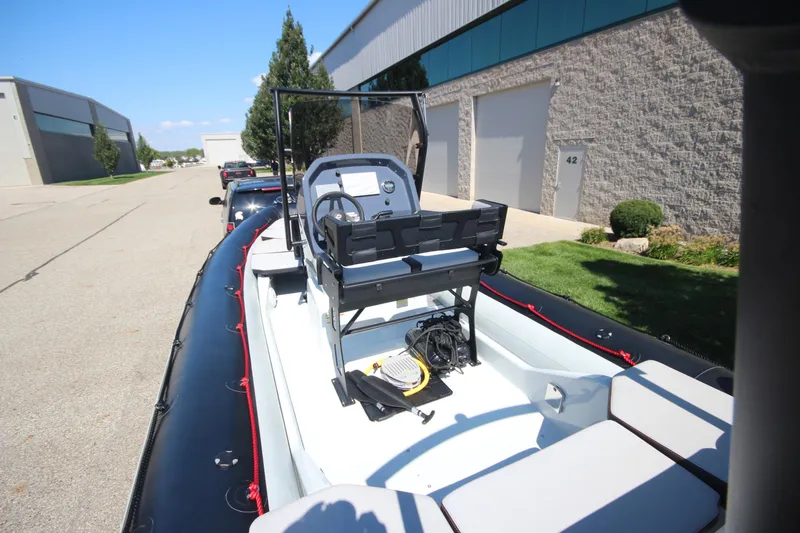 Slide: The Image of 2018 Zodiac Open 7 NEO boat on trailer, parked near industrial buildings. - 6
