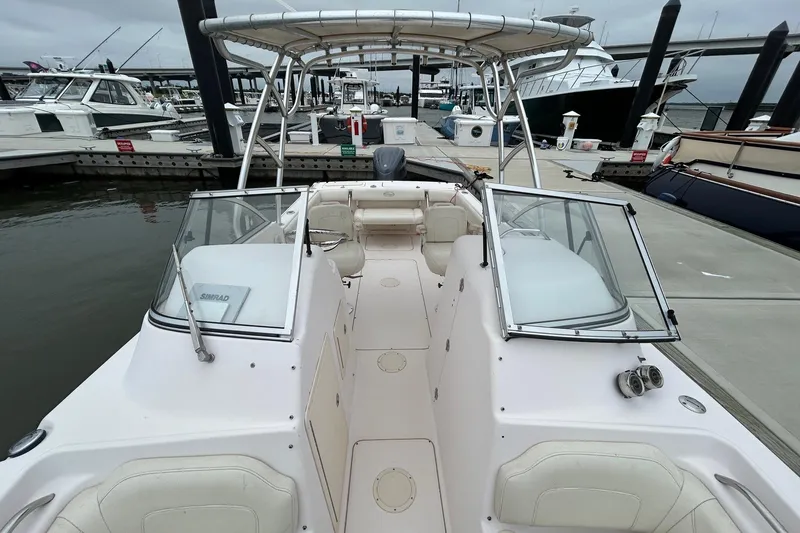 Slide: The Image of 2011 Grady-White Freedom 225 boat docked at marina, featuring spacious seating and canopy. - 18