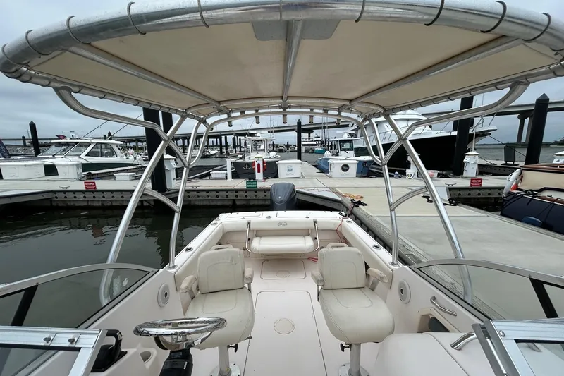 Slide: The Image of 2011 Grady-White Freedom 225 boat docked at a marina, featuring spacious seating and canopy. - 19