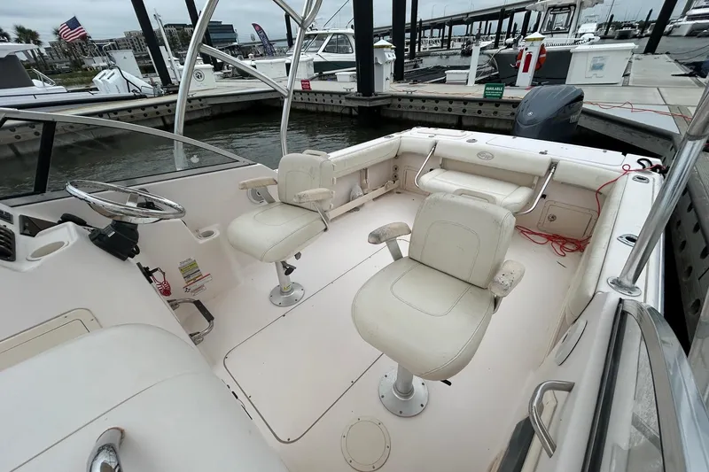 Slide: The Image of 2011 Grady-White Freedom 225 boat interior at marina, featuring seating and steering wheel. - 6