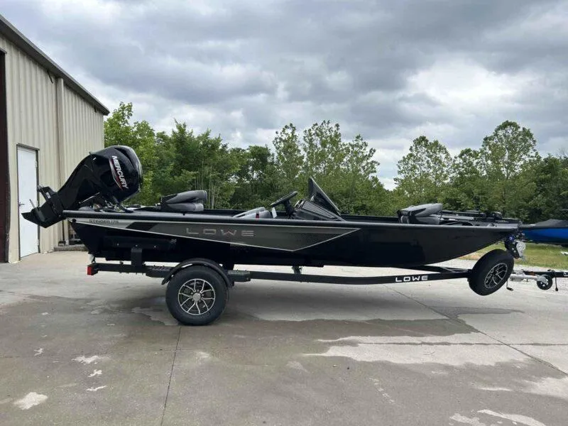 Slide: The Image of 2025 Lowe Stinger 175 Crappie boat on trailer, parked outdoors under cloudy sky. - 1