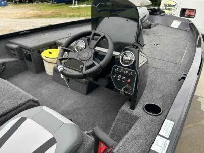 Slide: The Image of 2025 Lowe Stinger 175 Crappie boat interior with steering wheel and dashboard controls. - 7