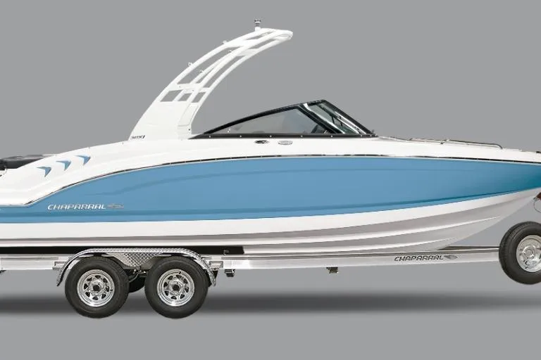 The Image of 2026 Chaparral 21 SSi boat on trailer in showroom, featuring sleek blue and white design. - 0