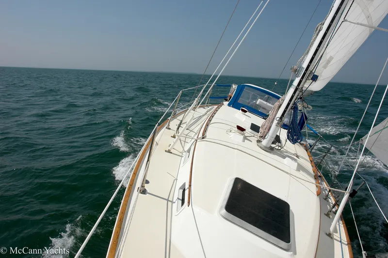 Slide: The Image of 1984 Sabre 32 Aft-Cabin sailboat navigating open sea under clear skies. - 13