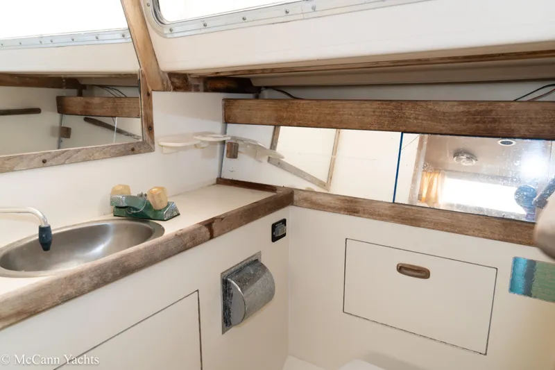 Slide: The Image of 1984 Sabre 32 Aft-Cabin yacht bathroom with sink, mirror, and wooden accents. - 35