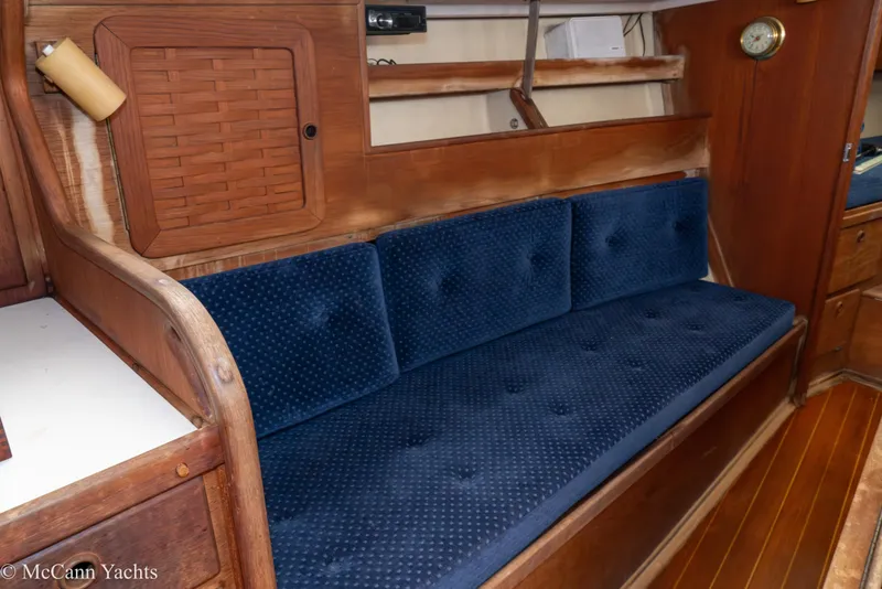 Slide: The Image of 1984 Sabre 32 Aft-Cabin interior with blue cushioned seating and wooden cabinetry. - 47