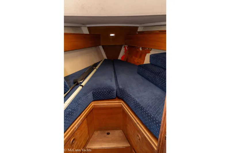 Slide: The Image of 1984 Sabre 32 Aft-Cabin interior with blue cushions and wooden cabinetry. - 49