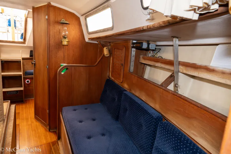 Slide: The Image of 1984 Sabre 32 Aft-Cabin interior with wooden paneling and blue cushioned seating. - 52