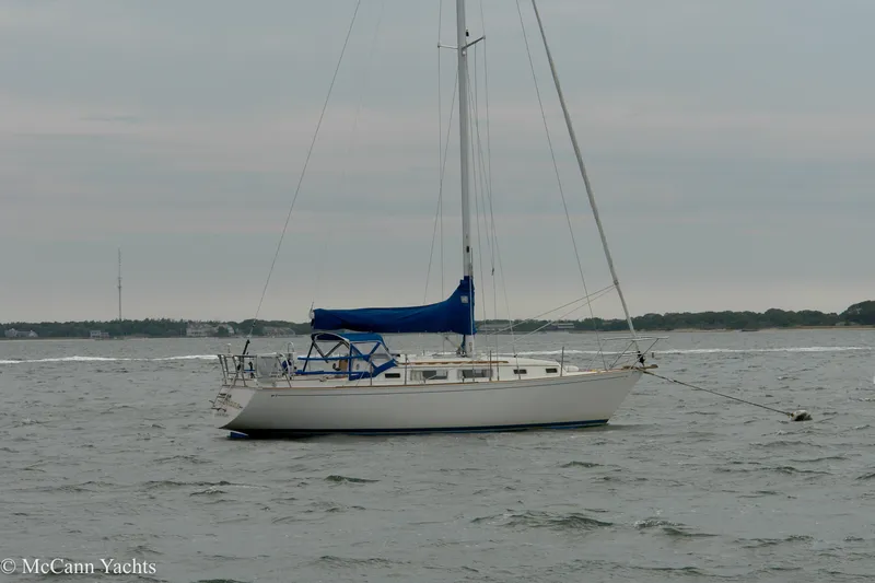 Slide: The Image of 1984 Sabre 32 Aft-Cabin sailboat anchored on calm waters under cloudy skies. - 55