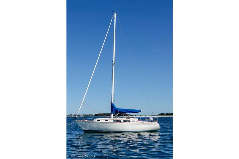Slide: The Image of 1984 Sabre 32 Aft-Cabin sailboat with blue sail cover on calm water. - 57