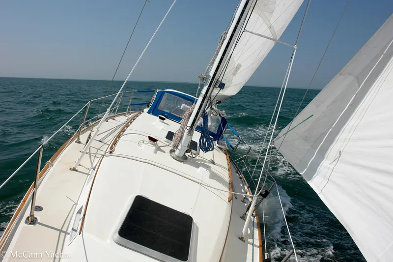 Slide: The Image of 1984 Sabre 32 Aft-Cabin sailboat navigating open sea with full sails. - 10