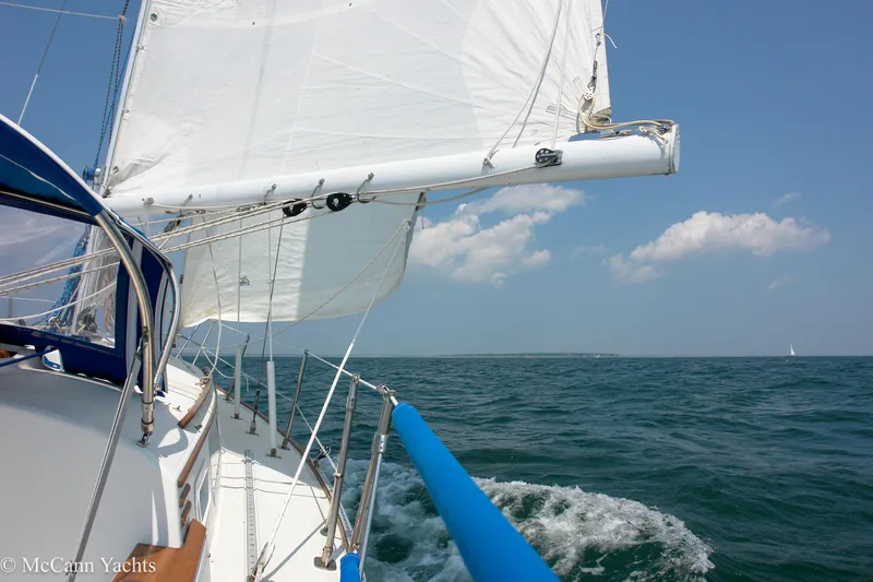Slide: The Image of 1984 Sabre 32 Aft-Cabin sailboat navigating open sea under clear blue sky. - 11