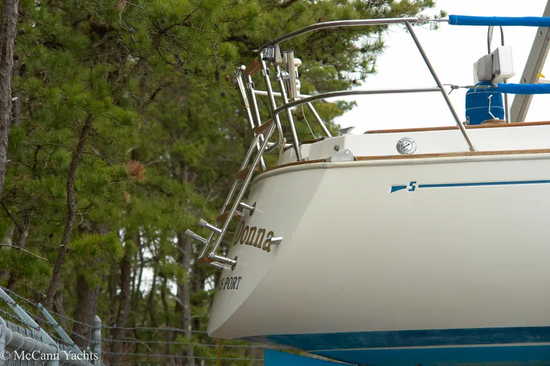 Slide: The Image of 1984 Sabre 32 Aft-Cabin yacht docked among trees, showcasing stern details. - 19