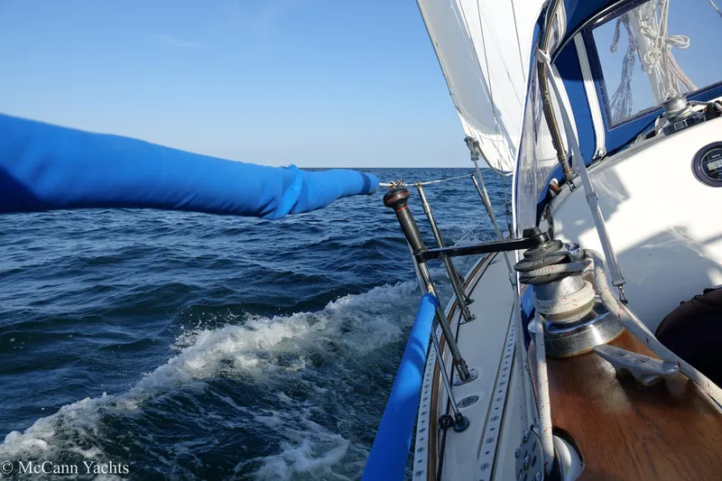 Slide: The Image of 1984 Sabre 32 Aft-Cabin sailboat navigating ocean waves under clear blue sky. - 24