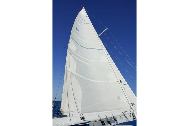 Slide: The Image of 1984 Sabre 32 Aft-Cabin sailboat with white sails against a clear blue sky. - 25