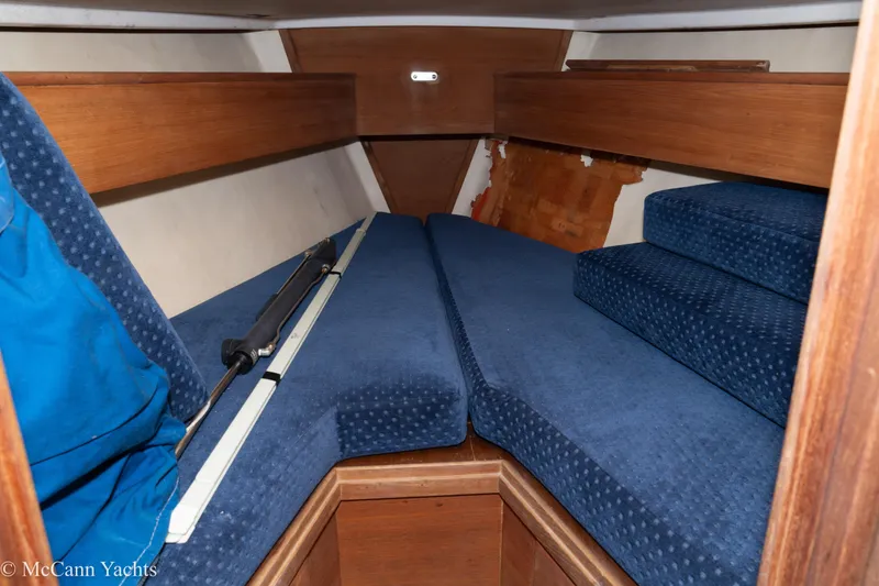 Slide: The Image of 1984 Sabre 32 Aft-Cabin interior with blue cushions and wooden accents. - 50